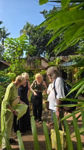a group of people standing in a garden at Cascara Beach Resort in Varkala