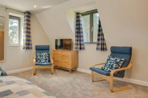 zwei Stühle und ein Fernseher in einem Schlafzimmer in der Unterkunft Peaty Cottage in Panxworth