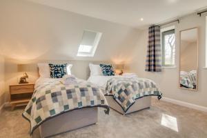 ein Schlafzimmer mit zwei Betten und einem Spiegel in der Unterkunft Peaty Cottage in Panxworth + 13 Fotos