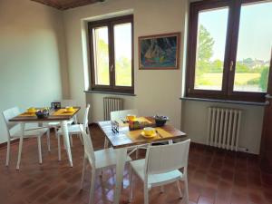 a dining room with two tables and chairs and windows at Cascina del Gelso - b&b in Santena