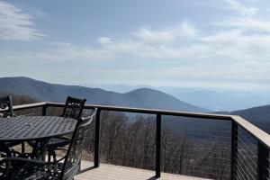 a table and chairs on a balcony with a view of mountains at Ledges 78 with Wintergreen Advantage in Wintergreen