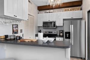 a kitchen with white cabinets and a stainless steel refrigerator at Laurelwood 48 with Wintergreen Advantage in Wintergreen