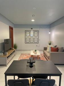 a living room with a table and a couch at شقق العليا الفندقية VIP - luxury in Al Khobar