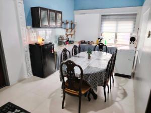 a kitchen with a table with chairs and a refrigerator at Roomstay Kak Ton DELUXE ROOM in Kuala Terengganu +14 photos