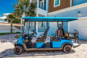 un carrito de golf estacionado frente a una casa en Blue Horizon Golf Cart Pool & Sleeps 32, en Santa Rosa Beach