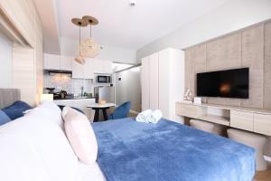 a bedroom with a blue bed and a kitchen at spacious studio with internet and Netflix in Cebu City