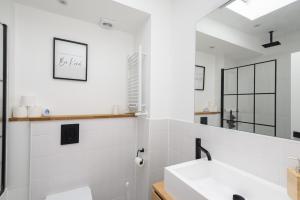 Un baño blanco con lavabo y espejo. en Spacious 4 Bedroom House by Oxford Train Station, en Oxford 77 fotos más