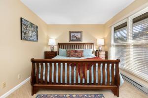 a bedroom with a wooden bed and two windows at Shenandoah Ridge 05 with Wintergreen Advantage in Wintergreen +17 photos