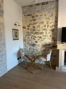 a dining room with a table and chairs against a stone wall at Le Boulevard Suites & Apartments in Olbia +21 photos