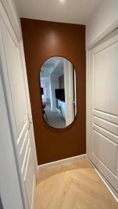 a hallway with a round mirror on a wall at Apartment Orléans in Orléans +1 photo
