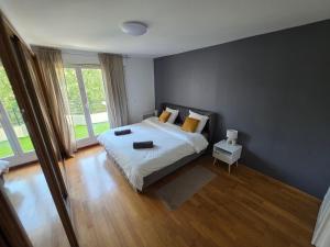 a bedroom with a bed and a large window at Grand appartement Proche Paris CDG Disney in Villepinte