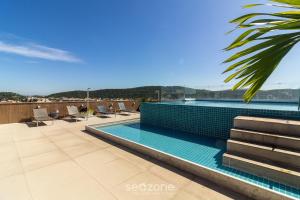 a swimming pool on the roof of a building at Estadia com piscina e sauna a poucos passos da praia em Cabo Frio - HSC in Škorak