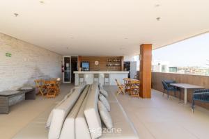 a room with couches and tables and chairs at Estadia com piscina e sauna a poucos passos da praia em Cabo Frio - HSC in Škorak