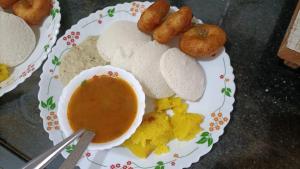 a plate of food with a bowl of dipping sauce at Hampi Lake House in New Hampi