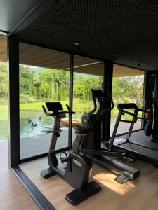una palestra con due tapis roulant e una grande finestra di Villa At On Organic Farm a Ban Wak