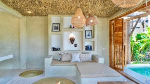 a room with a bed and a swimming pool at MAKU Oasis Villas and Studios in Makunduchi +43 photos