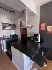 ブラジリアにあるApartamento Lake Sideのキッチン(黒いカウンタートップ、電子レンジ付)