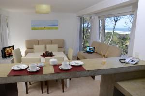 a kitchen and living room with a table and chairs at Jaina Resort & Spa in Mar de las Pampas