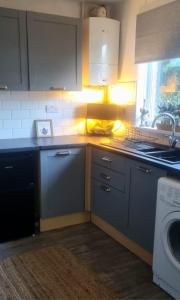 a kitchen with a sink and a washing machine at Contractor friendly-2 bd-Private Parking-Sleeps 3 in Llandeilo