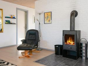 Una sala de estar con una silla y una chimenea. en 7 person holiday home in Knebel-By Traum, en Knebel