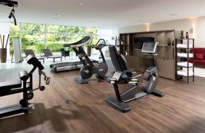 a gym with treadmills and cardio equipment in a room at Leonardo Hotel Mönchengladbach in Mönchengladbach
