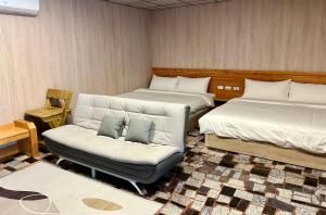 a living room with two beds and a couch at 夏日禾風會館 in Checheng