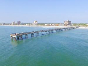 a pier in the middle of the water with a beach at Sunkissed Escape in Jacksonville Beach