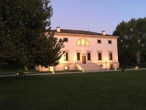a large white house with lights on the lawn at Villa Pisani Bonetti in Lonigo