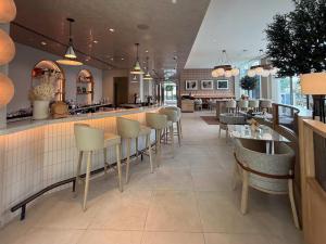 ein Restaurant mit Bar sowie Tischen und Stühlen in der Unterkunft Vida Dubai Mall Balcony with Burj & City Views walk to Dubai Mall by Heaven Crest Vacation Homes in Dubai