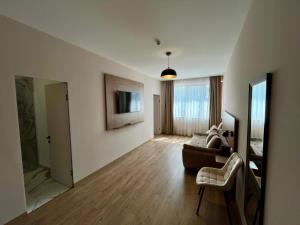 a living room with a couch and a tv on the wall at Stefanis Bulevard in Alba Iulia
