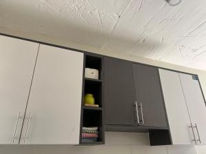 a kitchen with white cabinets and a white ceiling at A cozy spacious studio apartment with a balcony in Nairobi