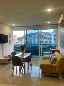 a living room with a yellow couch and a table at Apartamento Santa Marta Reserva del Mar 530 in Gaira