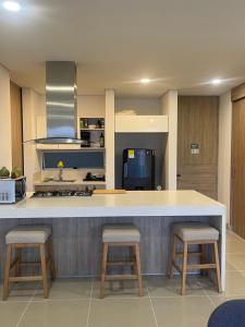 a kitchen with a large counter with two stools at Apartamento Santa Marta Reserva del Mar 530 in Gaira