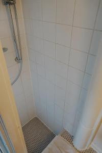 Un baño con ducha con azulejos blancos. en City center Amstel river Houseboat Kom en Zie, en Ámsterdam