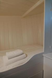 Una pequeña sauna blanca con dos toallas encima. en City center Amstel river Houseboat Kom en Zie, en Ámsterdam 7 fotos más