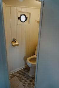 Baño pequeño con aseo y ventana en City center Amstel river Houseboat Kom en Zie, en Ámsterdam