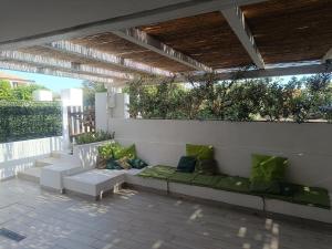 un patio con sofás sentados bajo una pérgola en I Fenicotteri Baia Caddinas, en Golfo Aranci