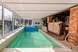 a swimming pool in a building with a large window at Magpie Cottage in Newton