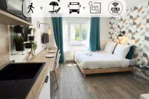 Un pequeño dormitorio con una cama y una cocina. en Les studios de l'Albatros, en Saint-Nazaire