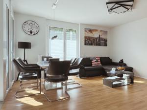a living room with a black couch and a table at Modern 3-Room Apartment in Stuttgart City Area in Stuttgart