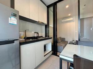 Pattaya the base condo في باتايا سنترال: مطبخ مع حوض وطاولة في الغرفة