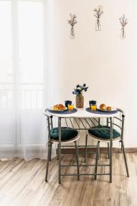 a table with two chairs and two plates of food on it at Villa Mona Studio Galets quartier des Cordiers in Le Tréport