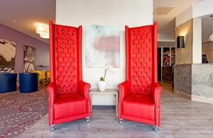 Dos sillas rojas una al lado de la otra en Leonardo Hotel Munich City North, en Múnich 32 fotos más