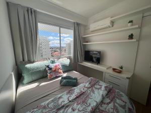 a small bedroom with a bed and a window at Nautilus Apto Beiramar Churrasqueira Piscina Beto Carrero in Penha +42 photos