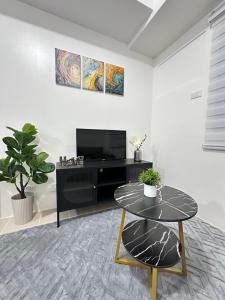 a living room with a table and a tv at Covent Garden Condominium in Manila