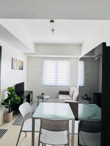 a living room with a glass table and chairs at Covent Garden Condominium in Manila