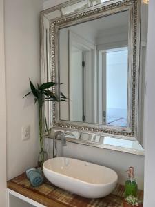 a bathroom with a white sink and a mirror at Nautilus Apto Beiramar Churrasqueira Piscina Beto Carrero in Penha