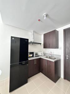 a kitchen with a black refrigerator and a sink at Covent Garden Condominium in Manila +4 photos