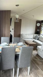 a living room with a table and chairs and a couch at Heysham Coastal Escape Family 3-Bed Caravan in Heysham