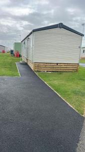 a large metal building on the side of a parking lot at Heysham Coastal Escape Family 3-Bed Caravan in Heysham
